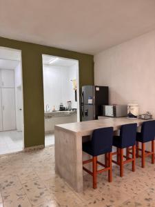 a kitchen with a table and chairs and a refrigerator at Casa verde El Platanar con Jardín Tropical Calkiní in Calkiní +12 photos