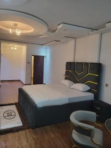 a bedroom with a large bed and a chair at HattiHome in Freetown