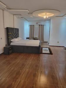 a bedroom with a large bed and a wooden floor at HattiHome in Freetown