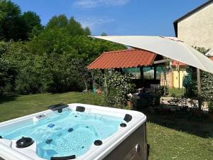 a hot tub in a yard with an umbrella at Ramoscello in Altare