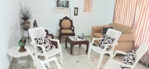 a living room with white chairs and a couch at Alojamiento Wilkenia in Ochoa +27 photos