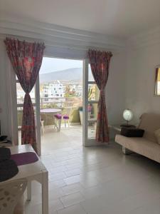 a living room with a couch and a glass door at Orlando Costa Adeje in Adeje