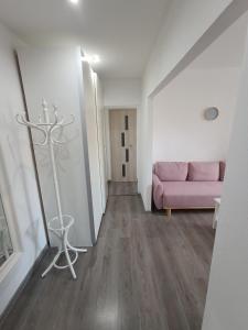 a living room with a pink couch and wooden floors at 1-room apartment in Nitra