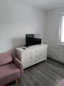 a living room with a couch and a flat screen tv at 1-room apartment in Nitra