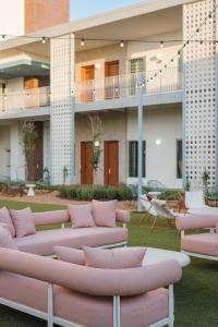 a courtyard with pink couches and tables and a building at Caravan Court Hotel in Arlington