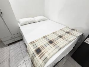 a bed in a white room with at Mini Ap no derby com Garagem in Sobral