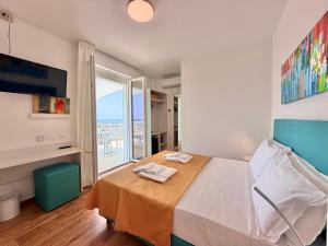 a bedroom with a bed and a large window at Hotel Royal Garnì in Caorle