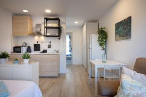 a kitchen and a living room with a table in a room at Acogedor studio a 10min de la playa in Torredembarra