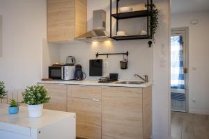 a kitchen with wooden cabinets and a sink at Acogedor studio a 10min de la playa in Torredembarra +4 photos