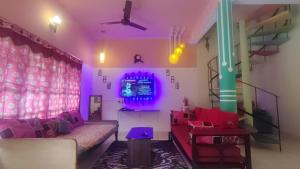 a living room with a couch and purple lighting at yercaud Happy valley cottage in Yercaud