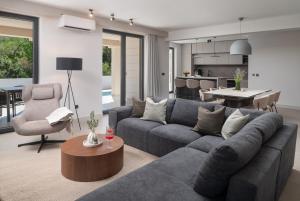 a living room with a gray couch and a table at Villa DaEva in Drage