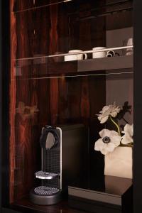 a computer monitor sitting on a shelf with flowers at Hôtel Atlas in Paris