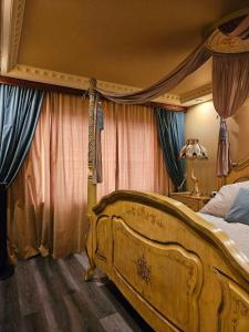 a bedroom with a large wooden bed with curtains at Royal View Apartment in Liepāja