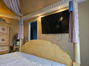 a bedroom with a bed with a television on the wall at Royal View Apartment in Liepāja