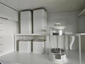 a white kitchen with a blender on a counter at Royal View Apartment in Liepāja