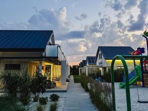 a house with a playground next to a house at Morski Raj Apartamenty in Dębki