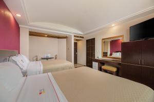 a hotel room with two beds and a television at Hotel & Villas Panamá in Mexico City +76 photos