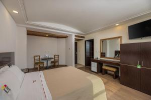 a bedroom with a bed and a desk and a television at Hotel & Villas Panamá in Mexico City