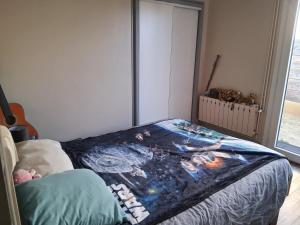 a bedroom with a bed with a painting on it at Maison proche bassin et océan in Arès