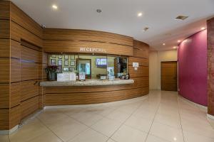 a hotel lobby with a reception counter and a pink wall at Hotel & Villas Panamá in Mexico City