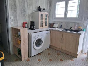 a kitchen with a washing machine and a sink at Maison proche bassin et océan in Arès