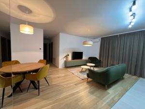 a living room with a table and chairs and a couch at Luxury Central Monarch Residence Apartment Sleeps 5 in Timişoara
