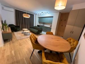 a living room with a dining room table and a kitchen at Luxury Central Monarch Residence Apartment Sleeps 5 in Timişoara