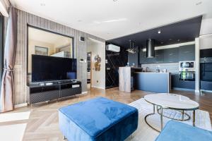 a living room with a large tv and a table at Elite House Gold Apartment in Leányfalu