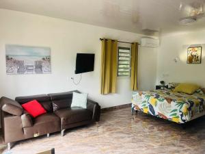 a living room with a couch and a bed at Bungalow tatayo in Aua