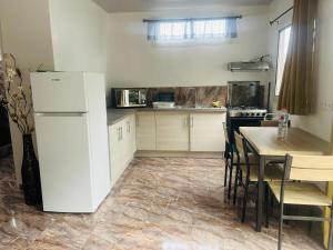 a kitchen with a white refrigerator and a table at Bungalow tatayo in Aua