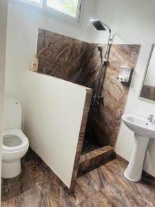 a bathroom with a toilet and a sink at Bungalow tatayo in Aua +1 photo
