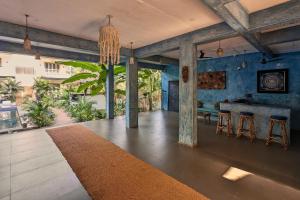 a living room with blue walls and a table and stools at Alpa Viram Retreat Goa in Mandrem