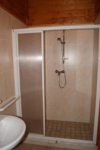 y baño con ducha y puerta de cristal. en Parco Vacanze Camping Sogno, en Marina di Massa