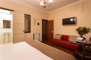 a bedroom with a bed and a red couch at Hotel York in Petrópolis