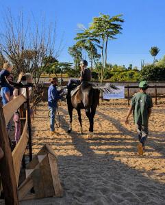 a woman is riding a horse while people watch at Mahafaly Hotel & Resort in Antsirabe