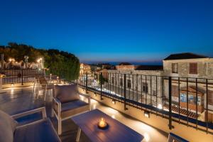 a patio with a table and chairs on a balcony at Karavel Suites - Old Town Boutique Rooms in Rhodes Town