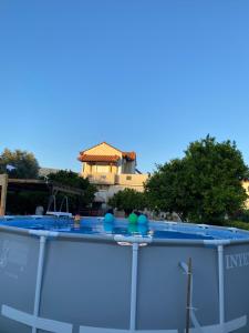 a swimming pool in front of a house at Family Home in Amarynthos