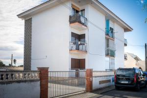a white house with a car parked in front of it at Acogedor studio a 10min de la playa in Torredembarra
