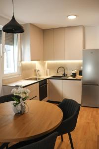 a kitchen with a table with a vase of flowers on it at MODERN ESCAPE apartment with garage in Split