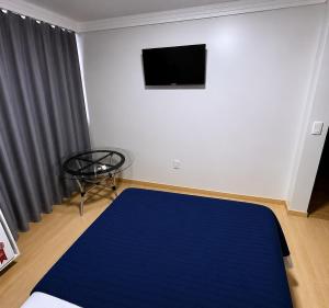 a bedroom with a bed and a flat screen tv at Loft Lux SM Chapecó - Amplo e aconchegante! in Chapecó