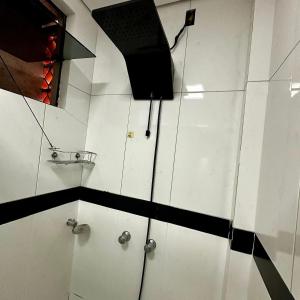 a bathroom with white cabinets and a black and white wall at Loft Lux SM Chapecó - Amplo e aconchegante! in Chapecó