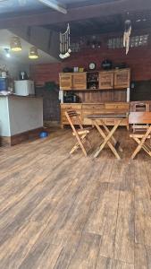 a room with wooden tables and chairs on a wooden floor at Pousada e SPA Shiva São Sebastião 200mts da praia in São Sebastião