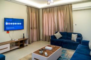 a living room with a blue couch and a tv at 407. Spacious 3BR Apt. 2 Baths Gated Community in Sheikh Zayed