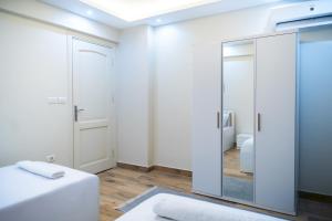 a white room with a mirror and a bed at 407. Spacious 3BR Apt. 2 Baths Gated Community in Sheikh Zayed +32 photos