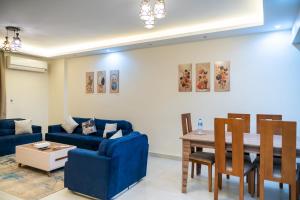 a living room with a blue couch and a table at 407. Spacious 3BR Apt. 2 Baths Gated Community in Sheikh Zayed