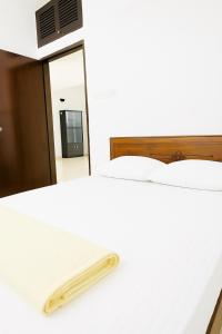 a bedroom with a white bed and a mirror at Elegant Residence Guest House in Dhaka