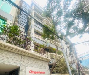 a building with a balcony with plants on it at Elegant Residence Guest House in Dhaka
