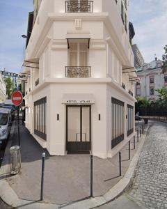 a white building with a sign in front of it at Hôtel Atlas in Paris