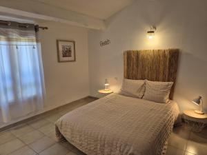 a bedroom with a bed and two lamps and a window at Clos de Valamade in Cannes-et-Clairan