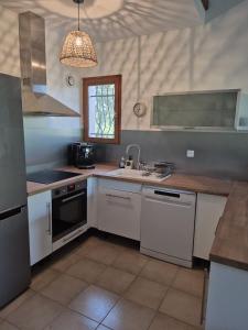 a kitchen with white cabinets and a sink at Clos de Valamade in Cannes-et-Clairan +11 photos